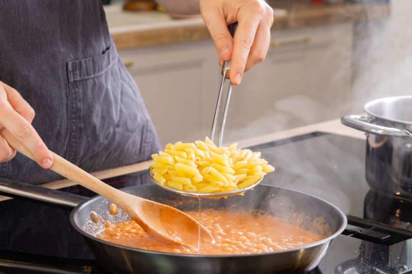 Nudeln in Sauce geben.