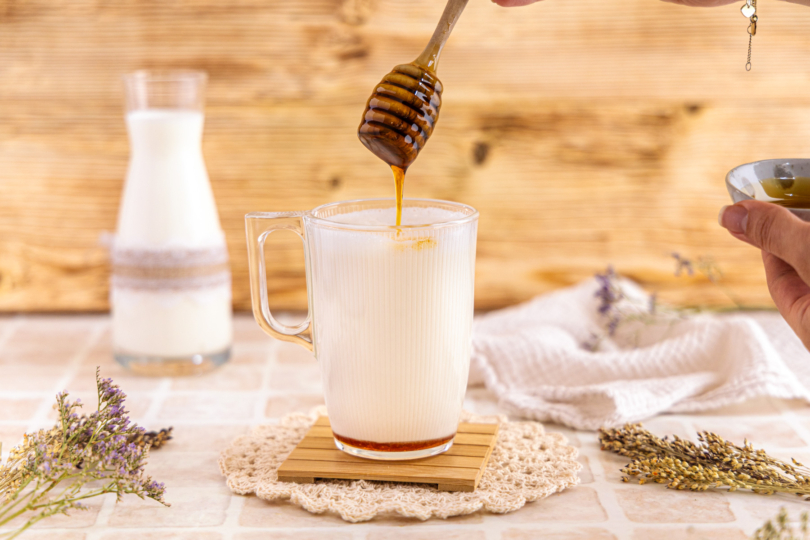 Heiße Milch mit Honig süßen