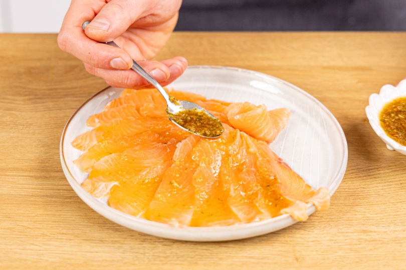 Lachs-Carpaccio mit Marinade beträufeln