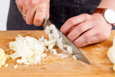 Zwiebel, Knoblauch und Ingwer in feine Würfel schneiden