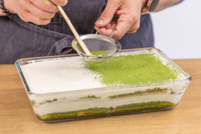 Matcha Tiramisu mit Matcha Pulver dekorieren