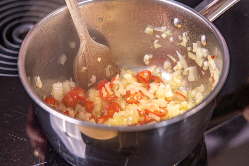 Zwiebeln, Knoblauch und Peperoni anbraten