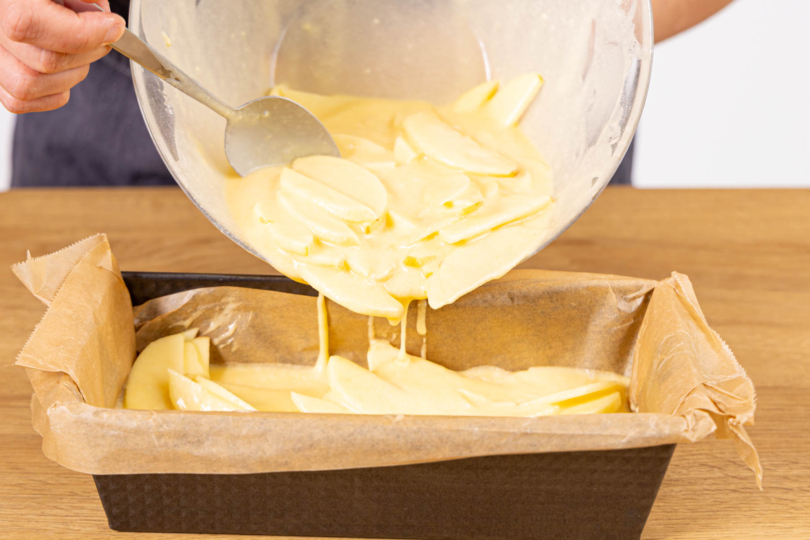 Teig mit Apfelspalten in die Kastenform gießen und backen