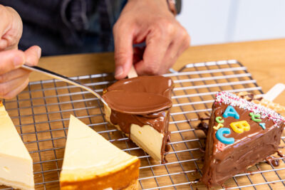 Kuvertüre über Tortenstücke geben