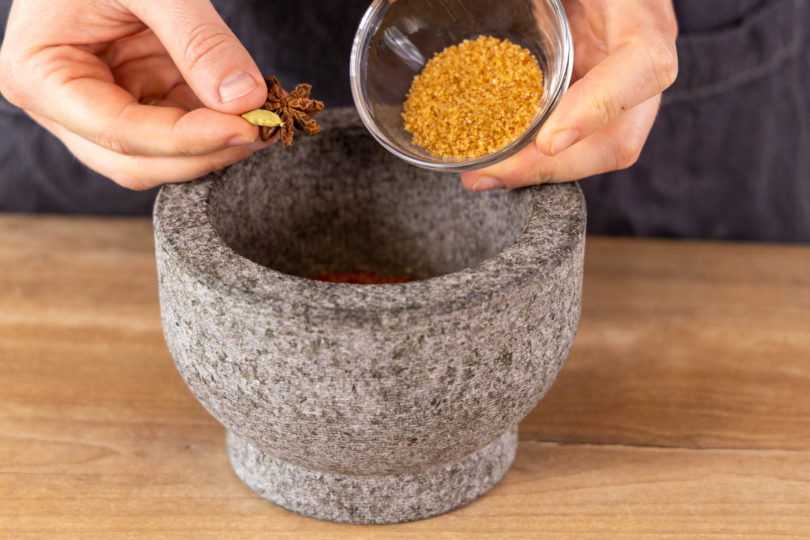 Gewürze uns Zucker in den Mörser geben
