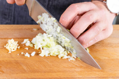 Zwiebeln und Knoblauch in feine Würfel schneiden
