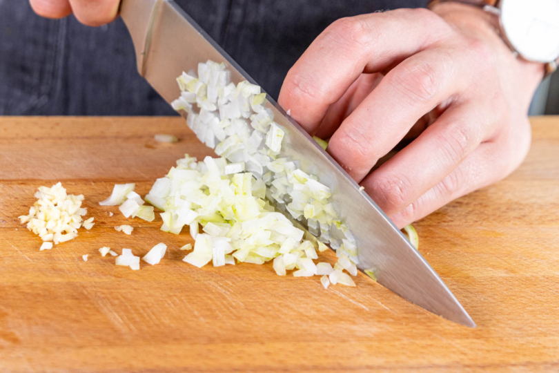 Zwiebeln und Knoblauch in feine Würfel schneiden