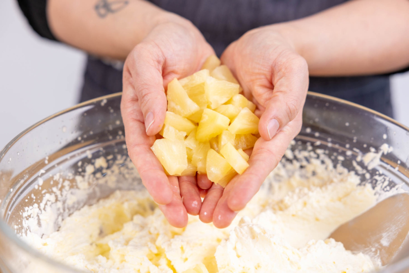 Ananas zur Sahnecreme geben
