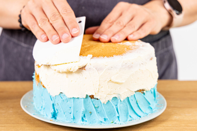 weiße Buttercreme auf die Torte streichen