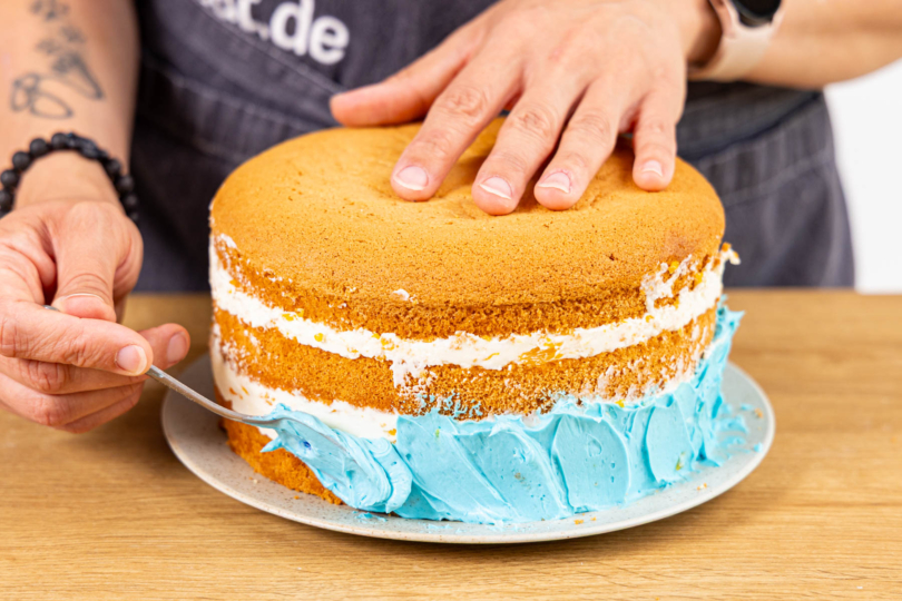 Torte mit blauer Buttercreme einstreichen
