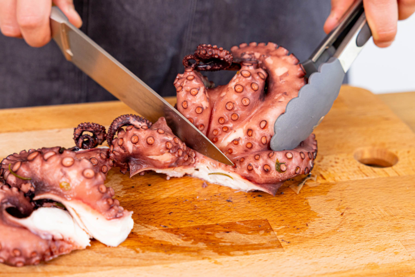 Tentakel des gekochten Oktopus kleinschneiden