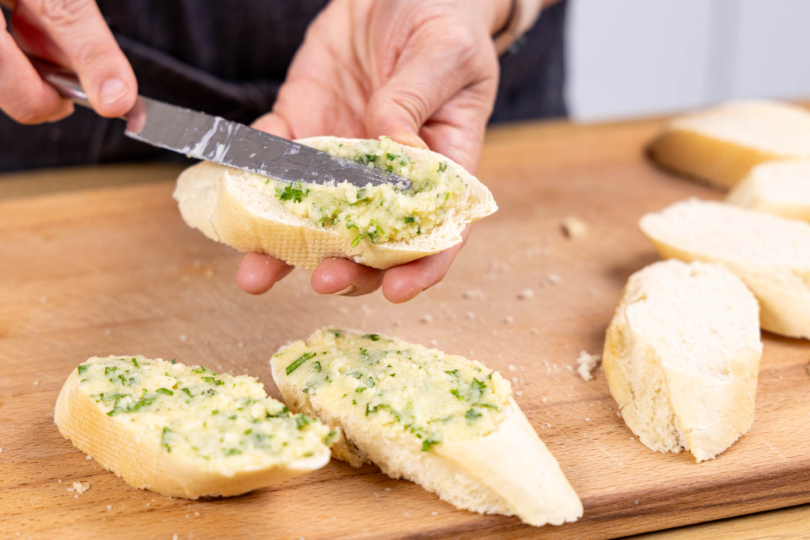Knoblauchbutter auf die Baguettescheiben streichen