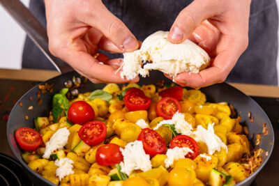 Mozzarella über Gnocchi-Gemüse-Pfanne zupfen