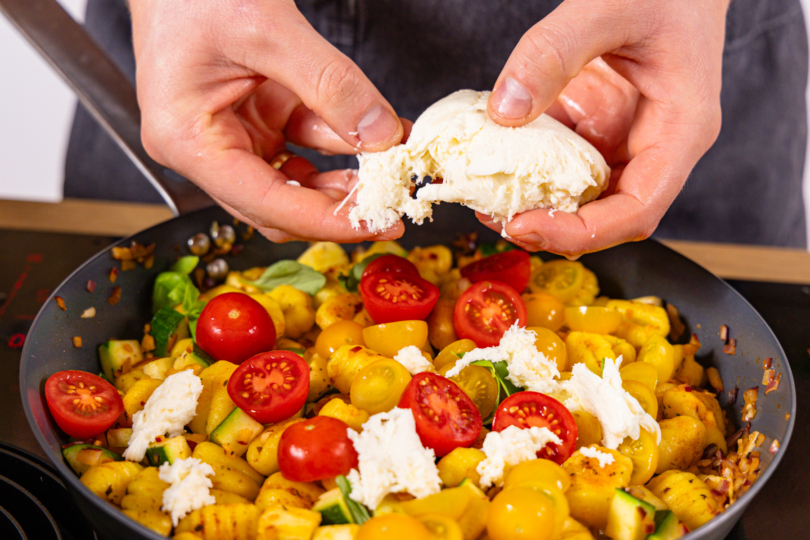 Mozzarella über Gnocchi-Gemüse-Pfanne zupfen