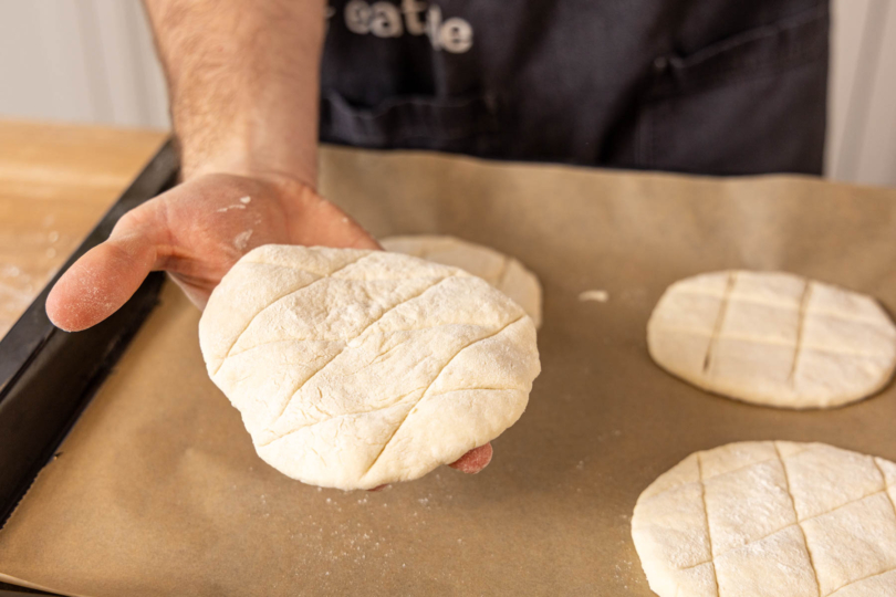 griechisches Pita-Fladenbrot aufs Blech legen