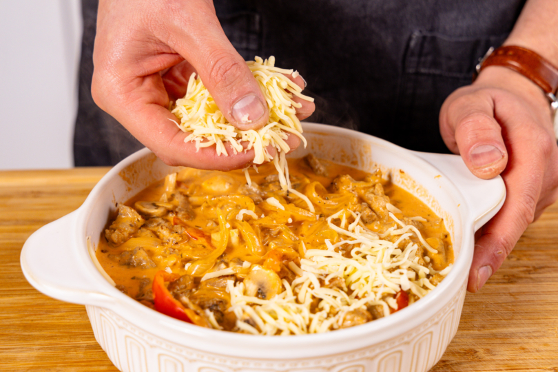 Gyrosauflauf mit Käse bestreuen