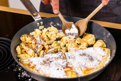 Holunderblüten-Kaiserschmarrn mit zwei Löffeln zerreißen