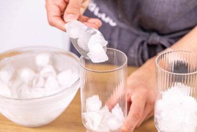Eiswürfel ins Glas geben