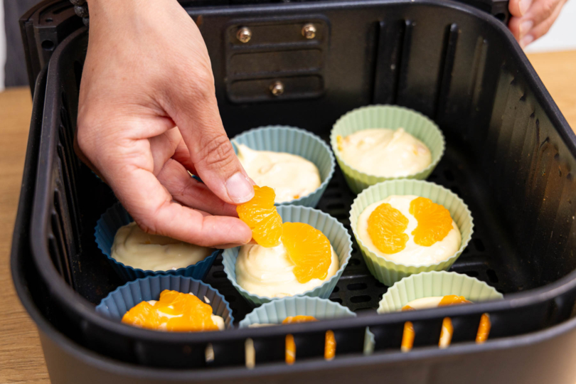 Mandarinenfilets auf die Käsekuchen-Muffins legen