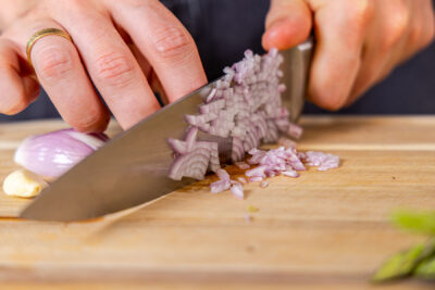 Zwiebel mit dem Messer klein schneiden