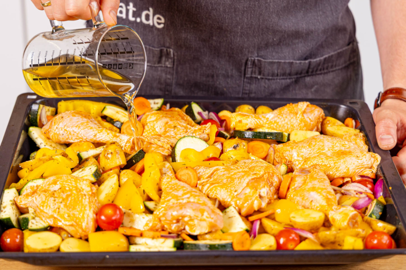 Mediterrane Hähnchenpfanne mit Gemüsebrühe angießen und im Ofen garen
