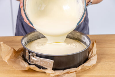 Käsekuchen-Masse in die Springform geben