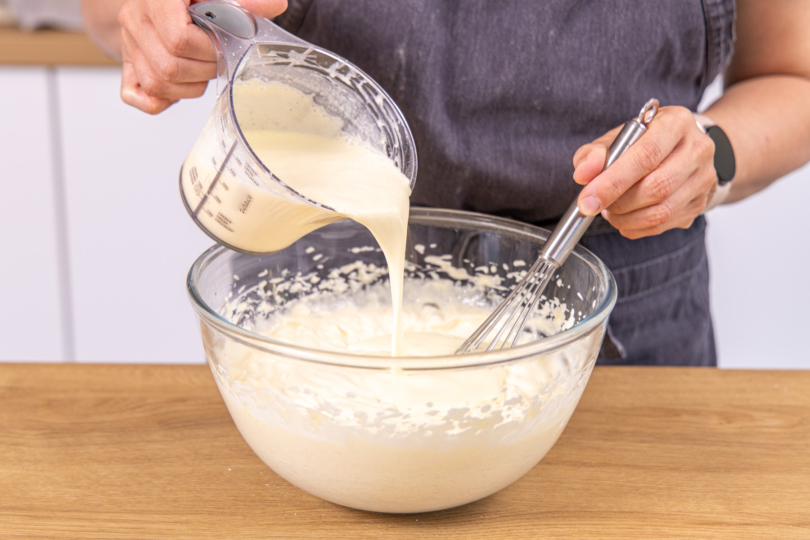 Sahne-Pudding-Masse zu dem Quark gießen