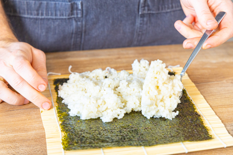 Sushi-Reis auf Nori-Blatt verteilen