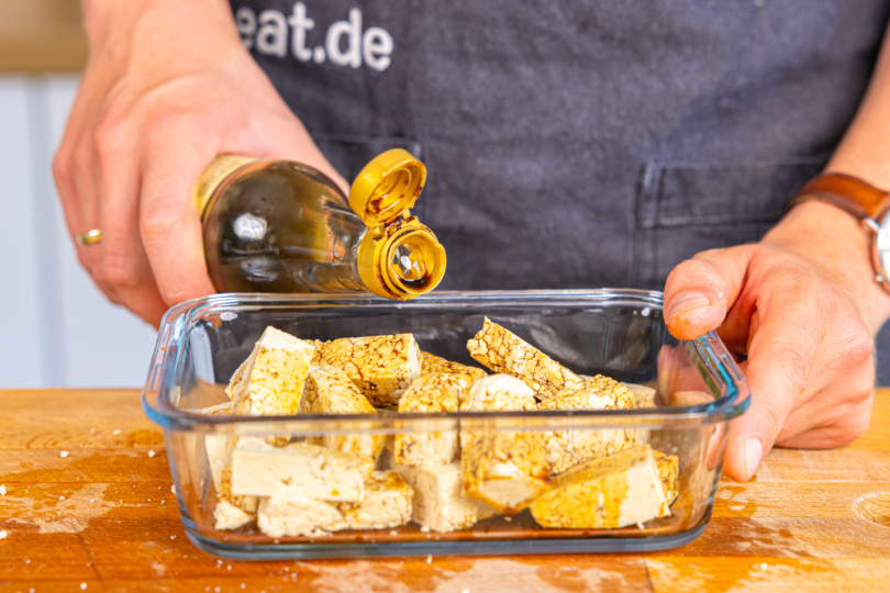 Tofu in Schüssel mit Sojasauce marinieren