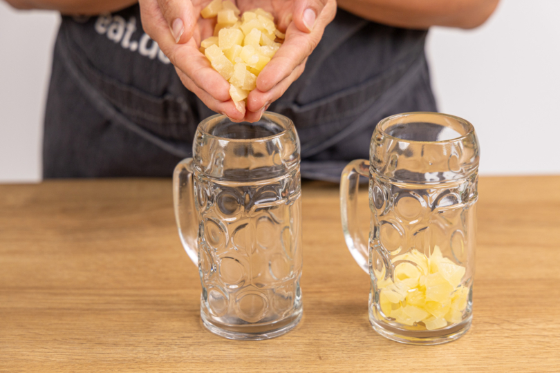 Ananas in Gläser geben