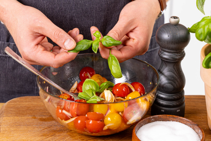 Italienischen Tomatensalat mit Basilikum garnieren