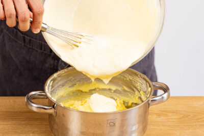 Quarkmasse unter den Vanillepudding rühren