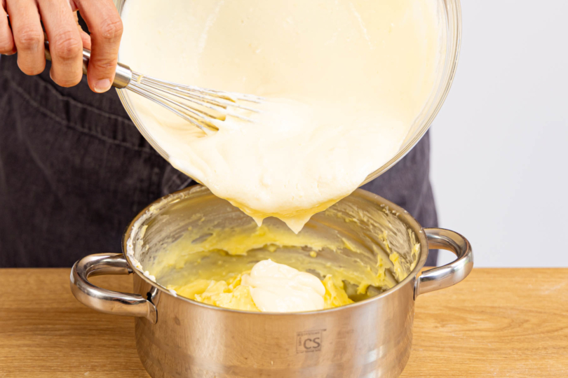 Quarkmasse unter den Vanillepudding rühren