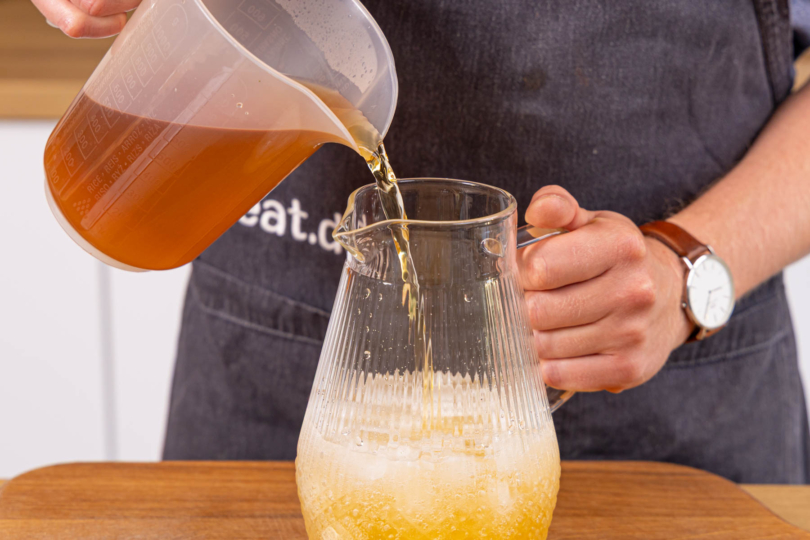 Limonadenansatz mit Mineralwasser und Eis mixen