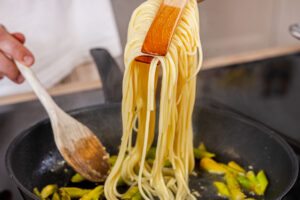 Spaghetti in Pfanne geben