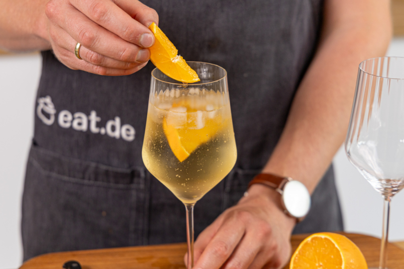 Orangenscheibe in den Lillet Spritz geben