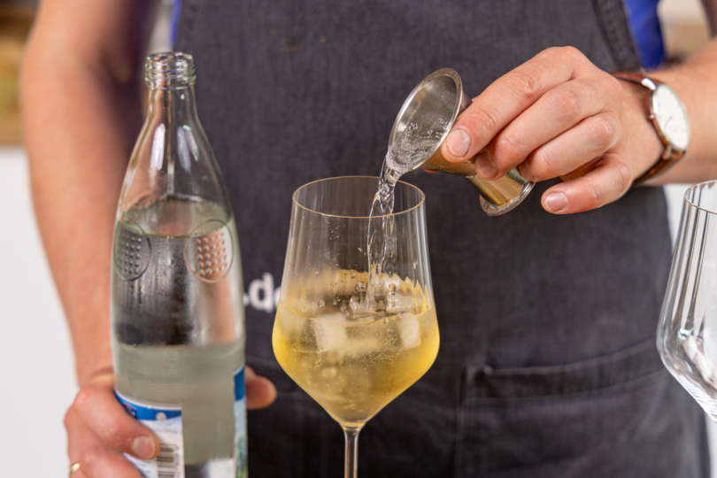 Mineralwasser ins Glas geben