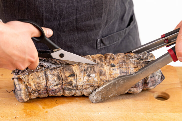 Tuch aufschneiden und die Salzkruste vom Fleisch kratzen