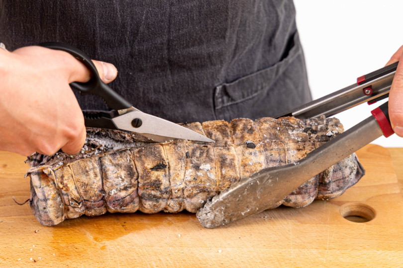 Tuch aufschneiden und die Salzkruste vom Fleisch kratzen