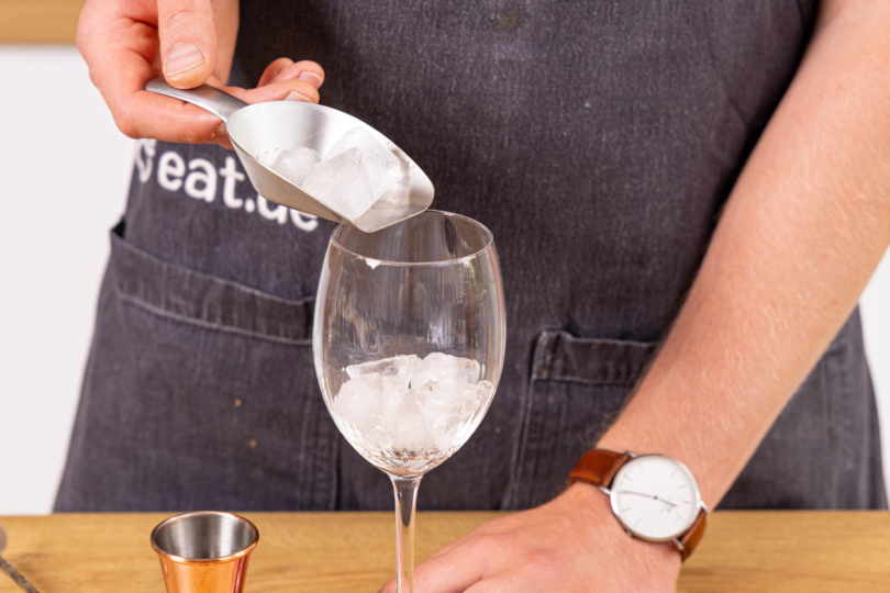 Eiswürfel ins Glas geben