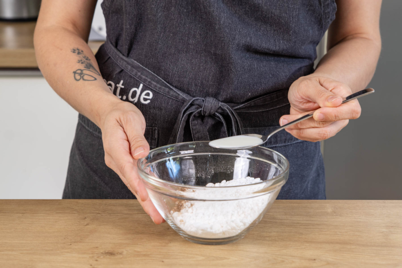 Milch zum Puderzucker und Zimt geben