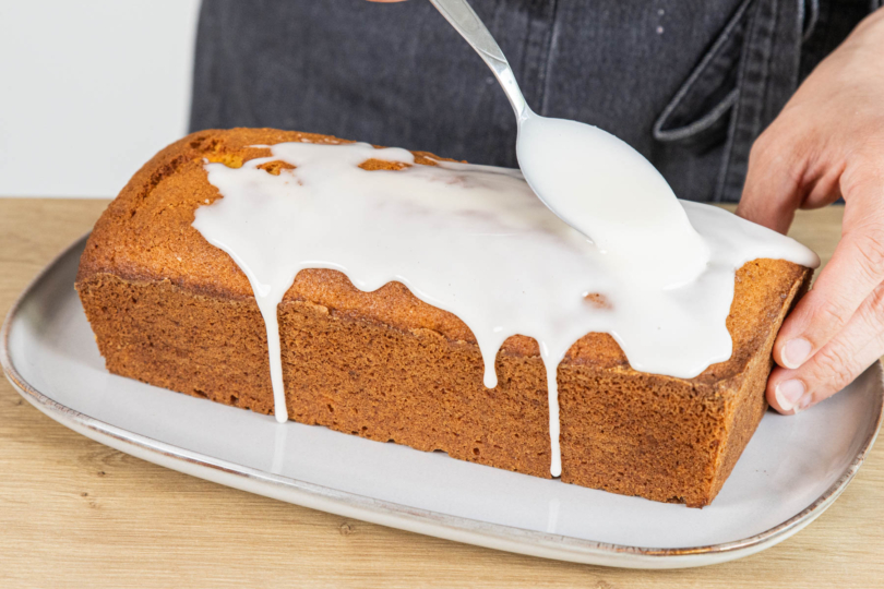 Glasur über den Orangenkuchen geben