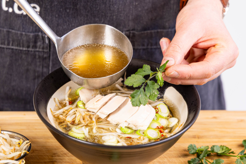 Pho Ga - vietnamesische Reisnudelsuppe abfüllen und servieren