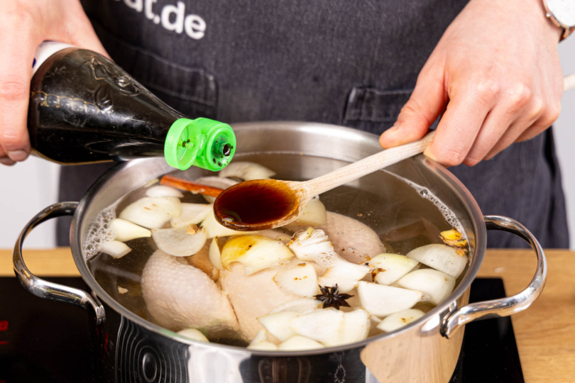 Brühe würzen und Suppenhuhn weich kochen