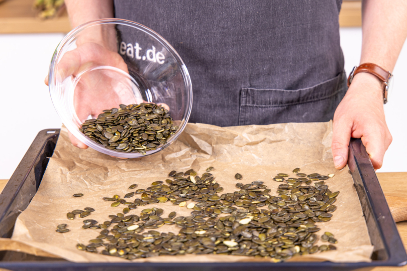 Kürbiskerne auf einem Blech verteilen