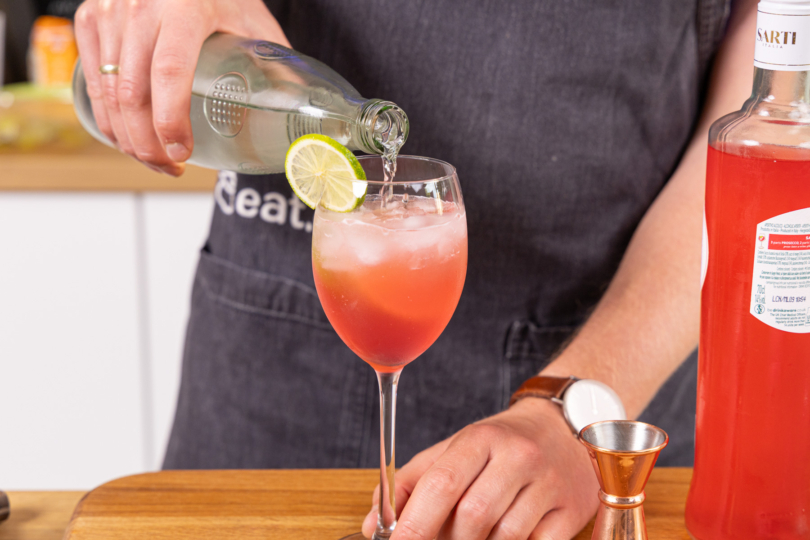 Sarti Spritz mit Sprudelwasser aufgießen