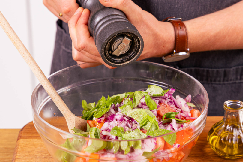 Tomatensalat mit Zwiebel marinieren und würzen