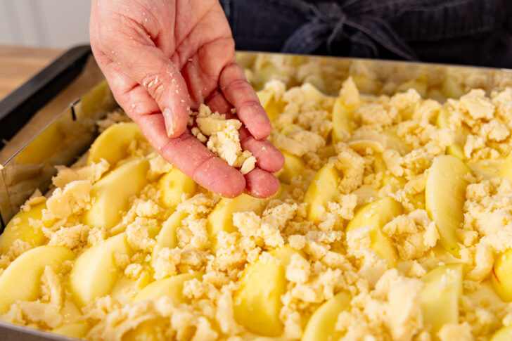 Streusel über den Äpfeln verteilen