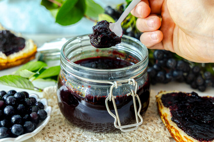 Aronia-Marmelade aus dem Glas nehmen