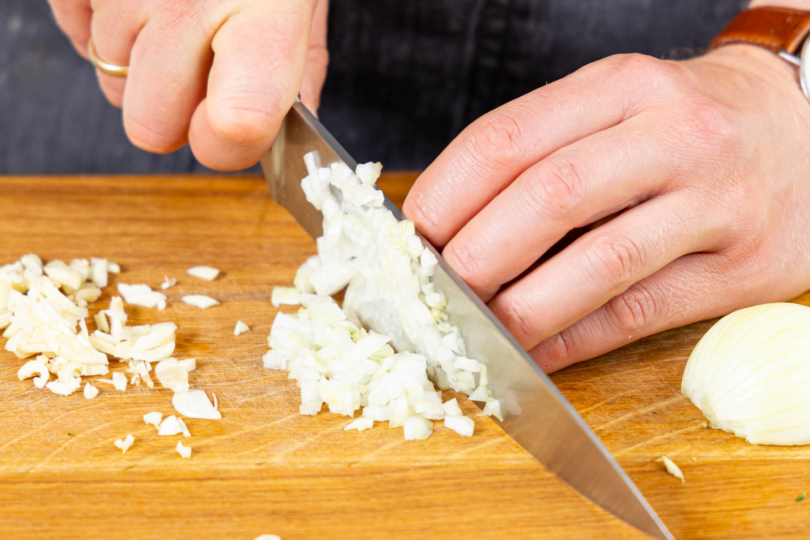 Zwiebel und Knoblauch in feine Würfel schneiden